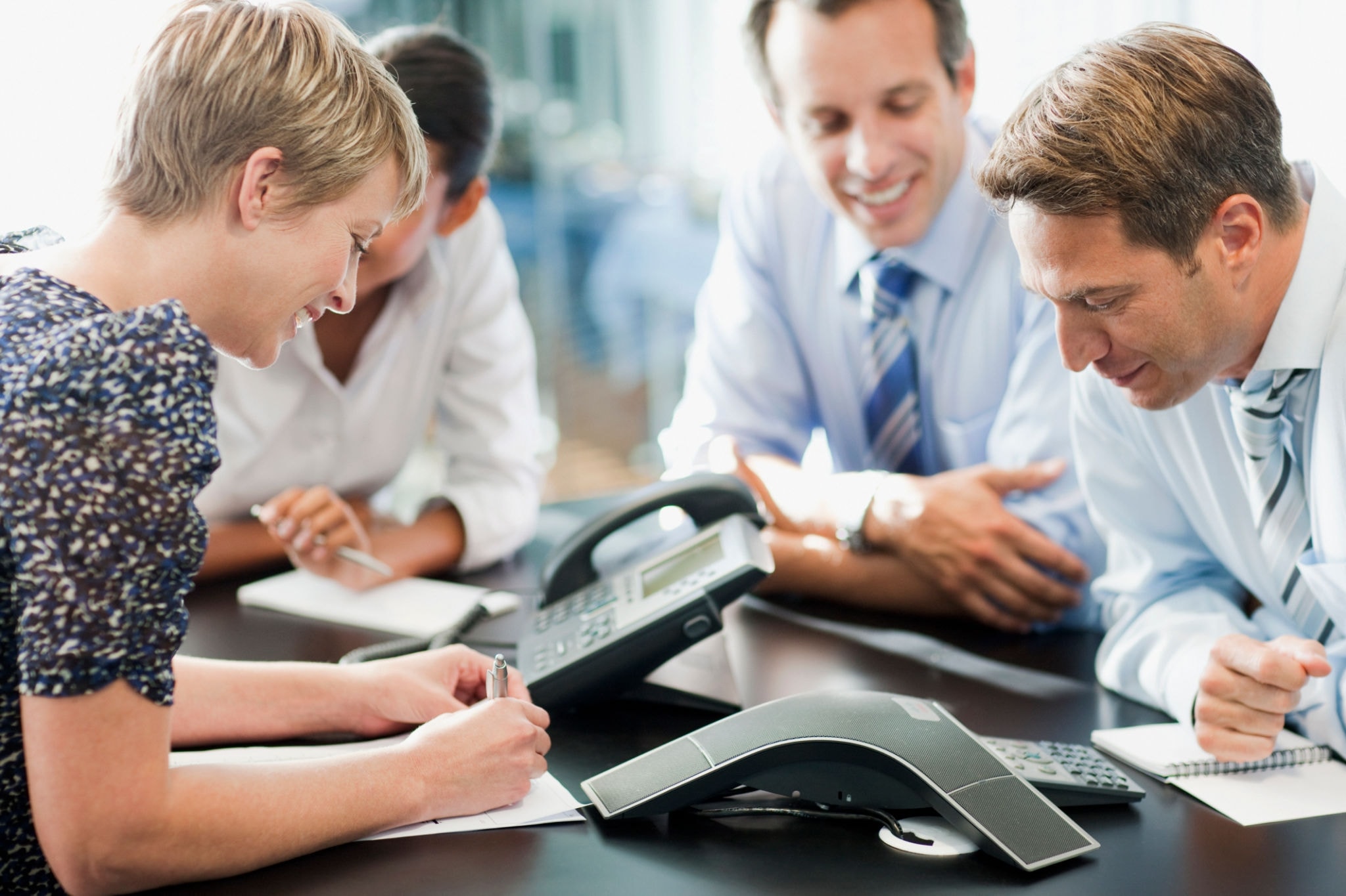 Business team collaborating around a conference phone